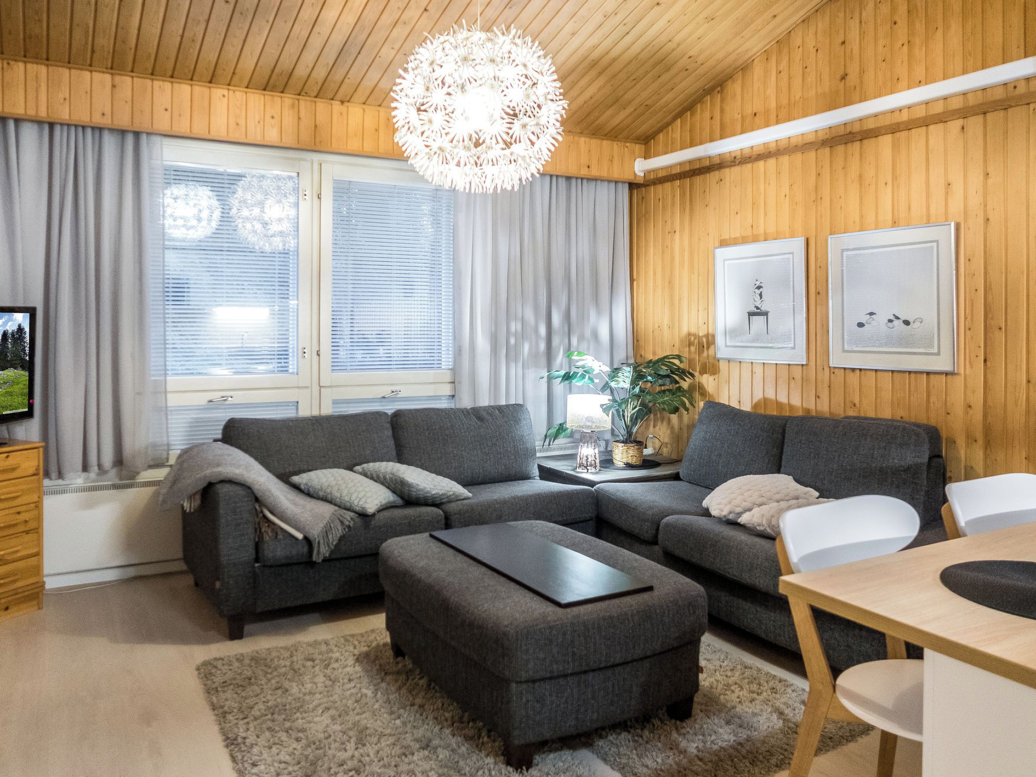 A modern living room with a sectional sofa, a coffee table, and a dining area with a table and chairs.
