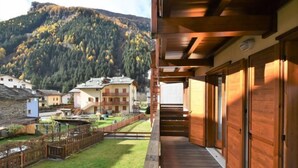 A wooden deck leading to a building with a mountain view.