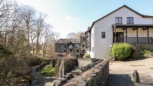 A stone bridge leading to a white building with a balcony. - Ghyll View (Ambleside)