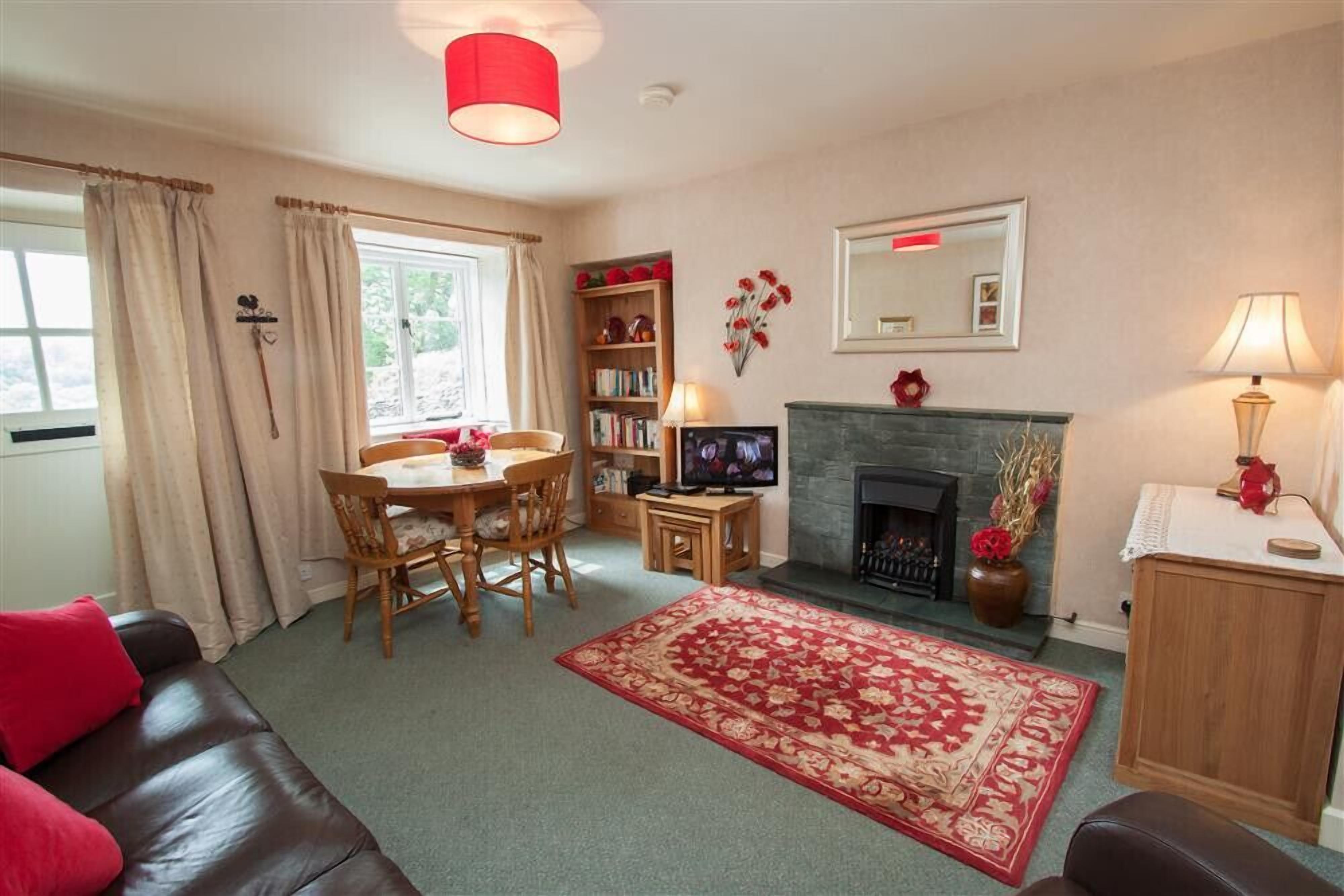 A cozy living room with a fireplace, a dining area, and a comfortable sofa.