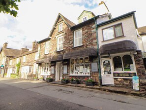 A traditional stone building with a shop on the ground floor, featuring a sign for an ice cream shop. - High Raise (Ambleside)