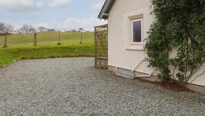 A gravel driveway leading to a cottage with a window and a door. - Larch Cottage (Ambleside)