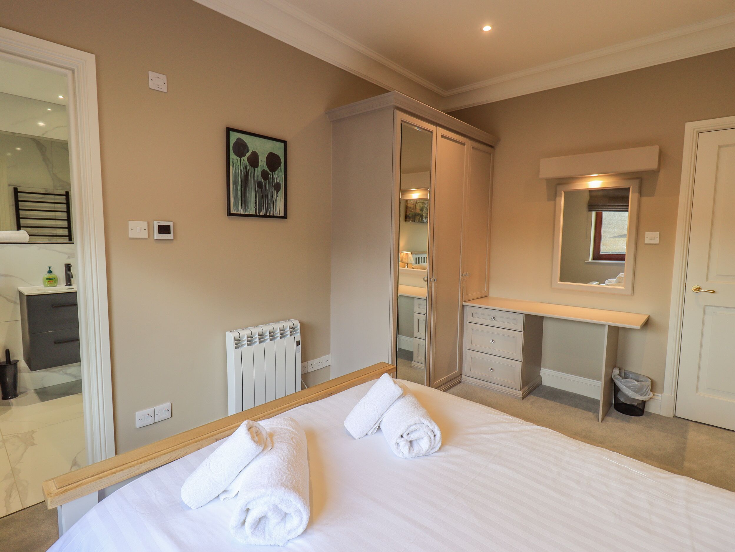 Una habitación de hotel con cama, baño y vestidor.