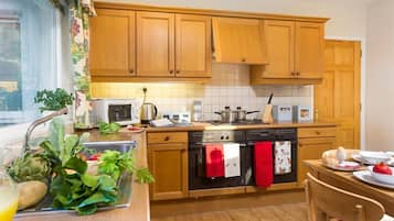 Een koelkast, kookgerei, borden en bestek