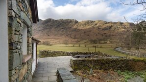 A stone building with a stone staircase leading to a patio area. - Thirlmere Cottage (Keswick)