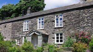 A stone building with multiple windows and a small porch. - Thomas Grove House (Penrith)