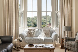 A cozy living room with a sofa, a coffee table, and a lamp. - Wetherlam (Ambleside)