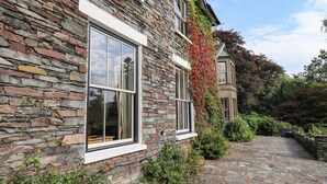 A stone building with large windows and a stone pathway leading to a door. - Easedale (Ambleside)
