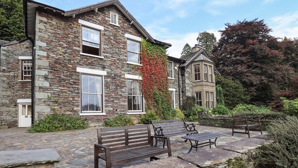 A stone building with a stone pathway, benches, and a small garden area. - Easedale (Ambleside)