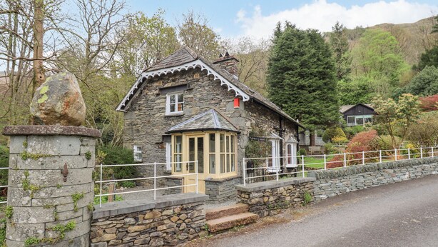 A stone building with a traditional design, featuring a small porch and a sign that reads "North Lodge." - North Lodge (Ambleside)