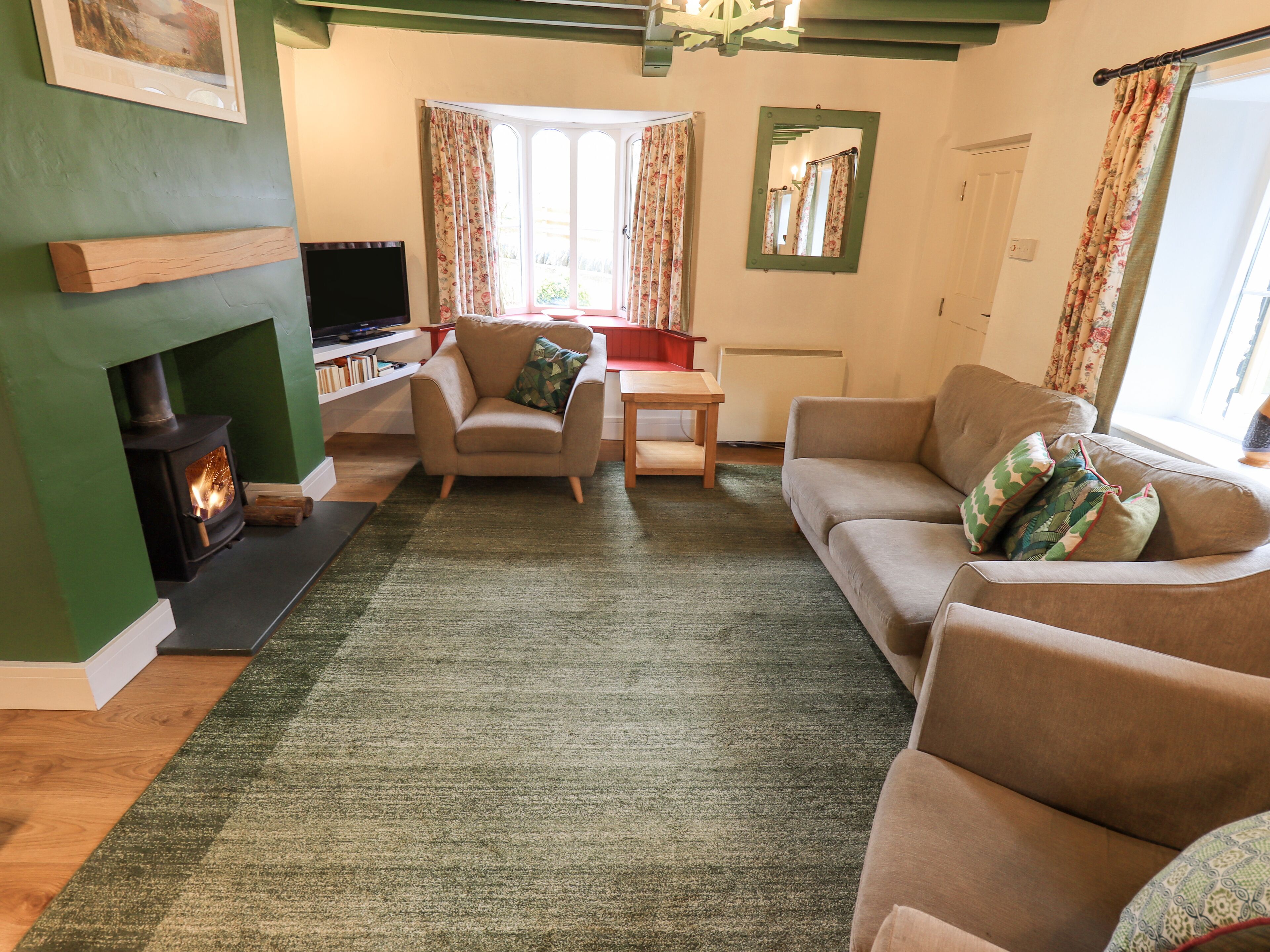 A cozy living room with a fireplace, a sofa, a chair, and a television.