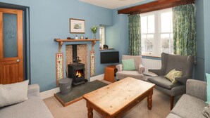 Ein Wohnzimmer mit Kamin, Fernseher und einer gemütlichen Sitzecke.