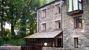 A stone building with multiple windows and a covered porch. - Over Ghyll (Ambleside)