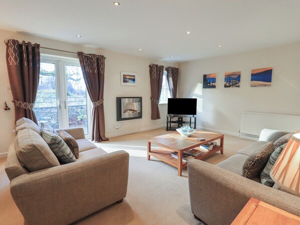 A living room with a fireplace, a television, and a sofa. - Wansfell (Ambleside)