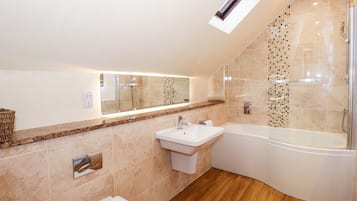A modern bathroom with a shower, sink, and toilet.