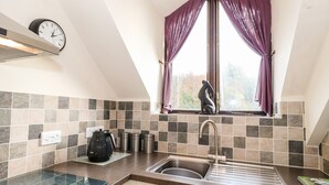 A kitchen with a window, a clock, and a kettle. - Squirrel Bank (Ambleside)