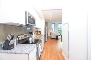 A modern kitchen with a built-in microwave, stove, and coffee maker.