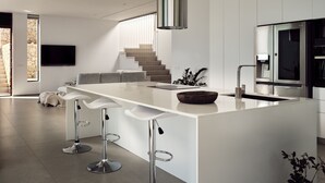 A modern kitchen with a large island, bar stools, a built-in oven, and a staircase leading to an upper level. - The Sall Villa - 2 Bedrooms with Private Pool & Sea View (Volimes)