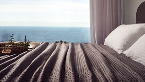 A bedroom with a view of the sea, a bed with white pillows, a woven blanket, and a small table with a cup and a plant. - The Sall Villa - 2 Bedrooms with Private Pool & Sea View (Volimes)