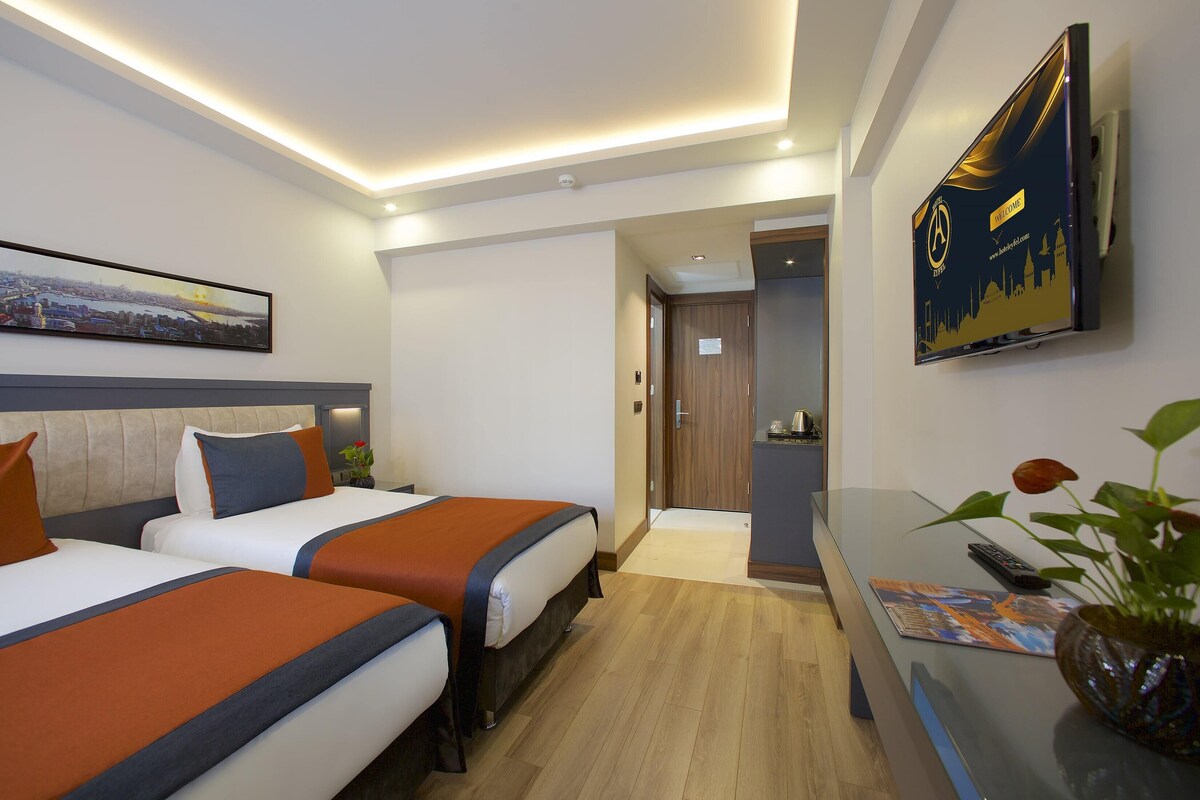 Deluxe Triple Room | Minibar, in-room safe, desk, laptop workspace
