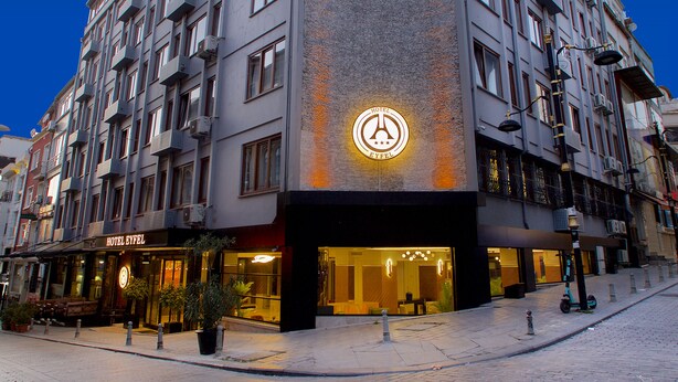 A hotel with a prominent sign, multiple floors, and a well-lit entrance. - Eyfel Hotel (Istanbul)