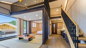 A modern interior with a wooden staircase, tatami flooring, and a view of a mountain. - Hotel Harusida (Seogwipo)