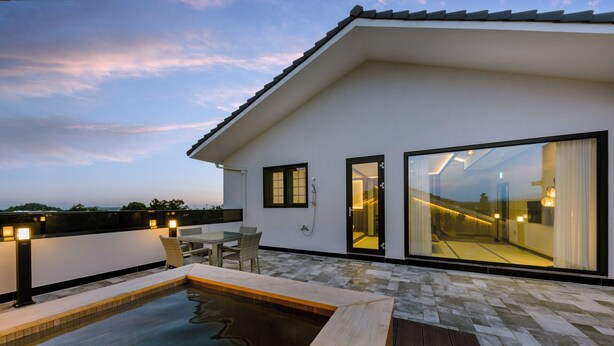 A modern house with a swimming pool, large glass doors, and outdoor lighting. - Hotel Harusida (Seogwipo)