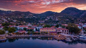 A coastal town with a marina, houses with red roofs, and a mountainous backdrop. - BASE Selimiye (Marmaris)