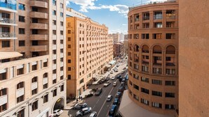 A multi-story building with a central courtyard, large windows, and a street with parked cars. - Apart-Hotel on King Pap Str. 4/6 (Yerevan)