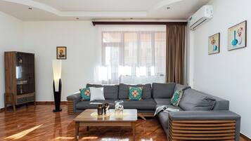 Superior appartement | Woonruimte | Een 55-inch flatscreentelevisie met kabelzenders