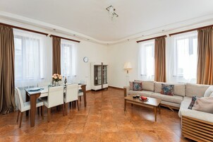 Een moderne woonkamer met een eethoek, een bank, een salontafel en een televisie.