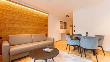 Una sala moderna con un sofá, una mesa de centro y un comedor con sillas.