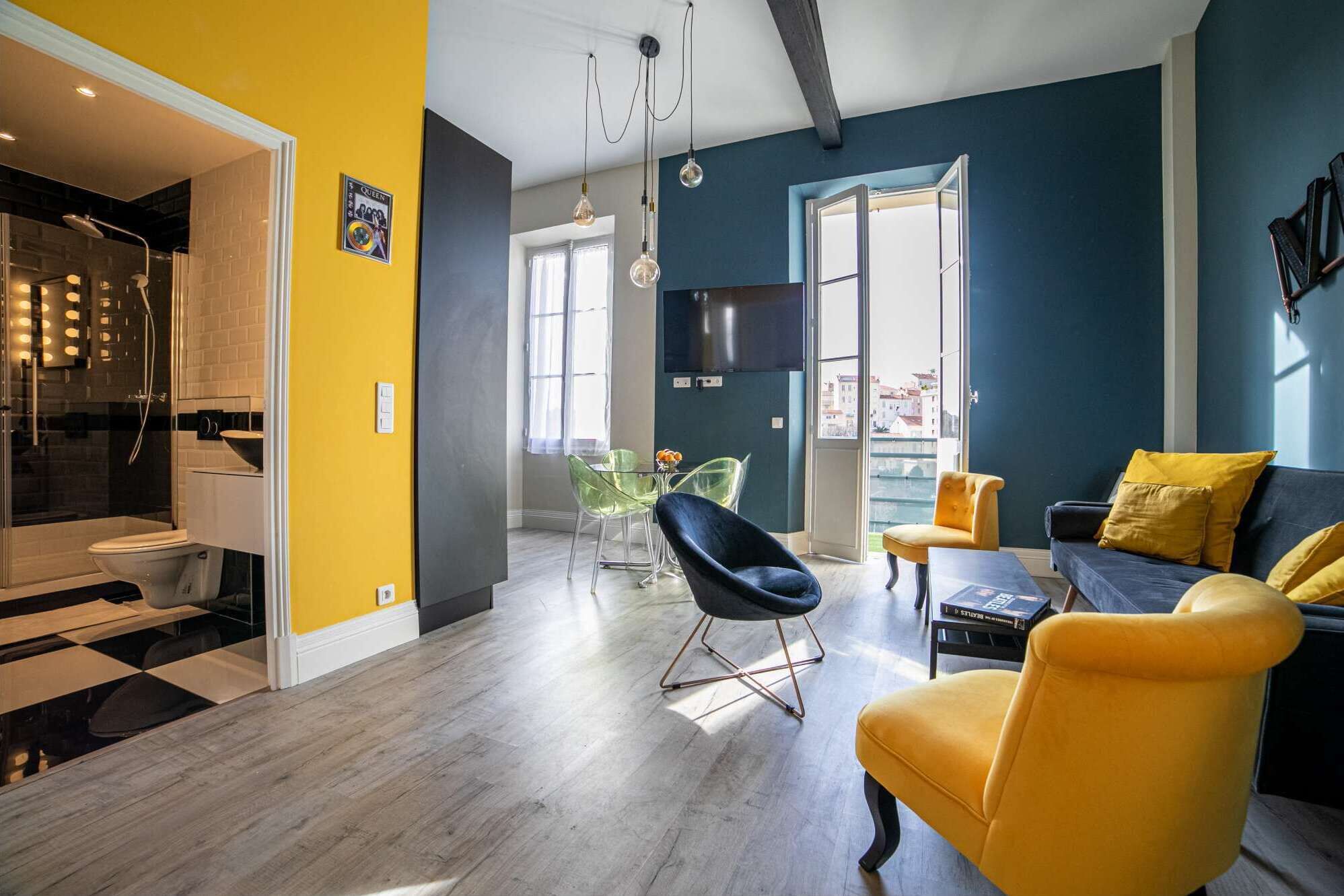 Una sala de estar moderna con un sofá, sillas y una zona de comedor.
