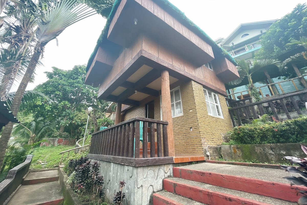A two-story building with a wooden balcony and a brick facade.