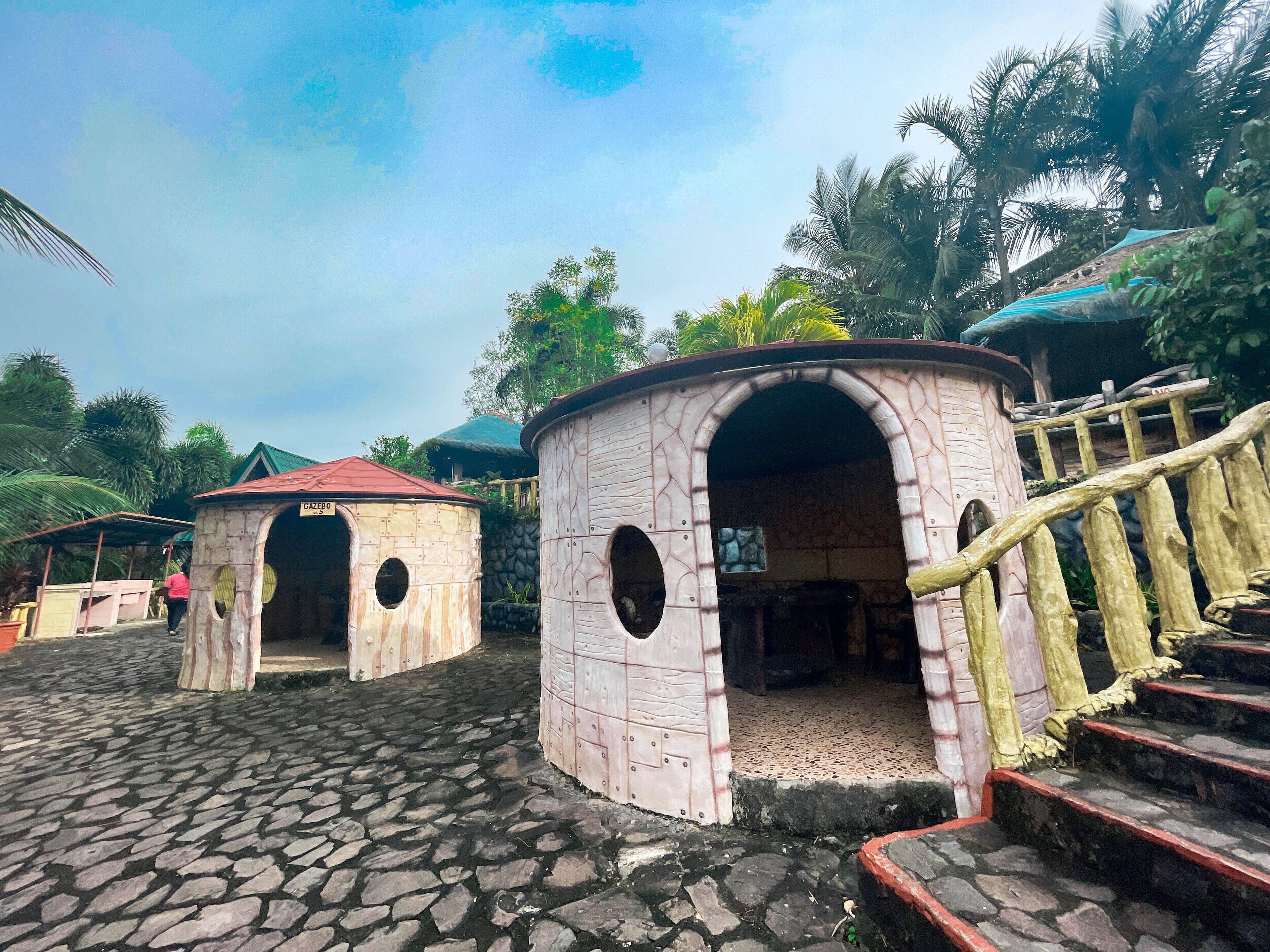 Un edificio rústico con suelo de piedra y una escalera de madera que conduce a una entrada.