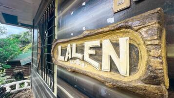 A rustic exterior with a wooden sign reading "LALEN" and a metal gate.
