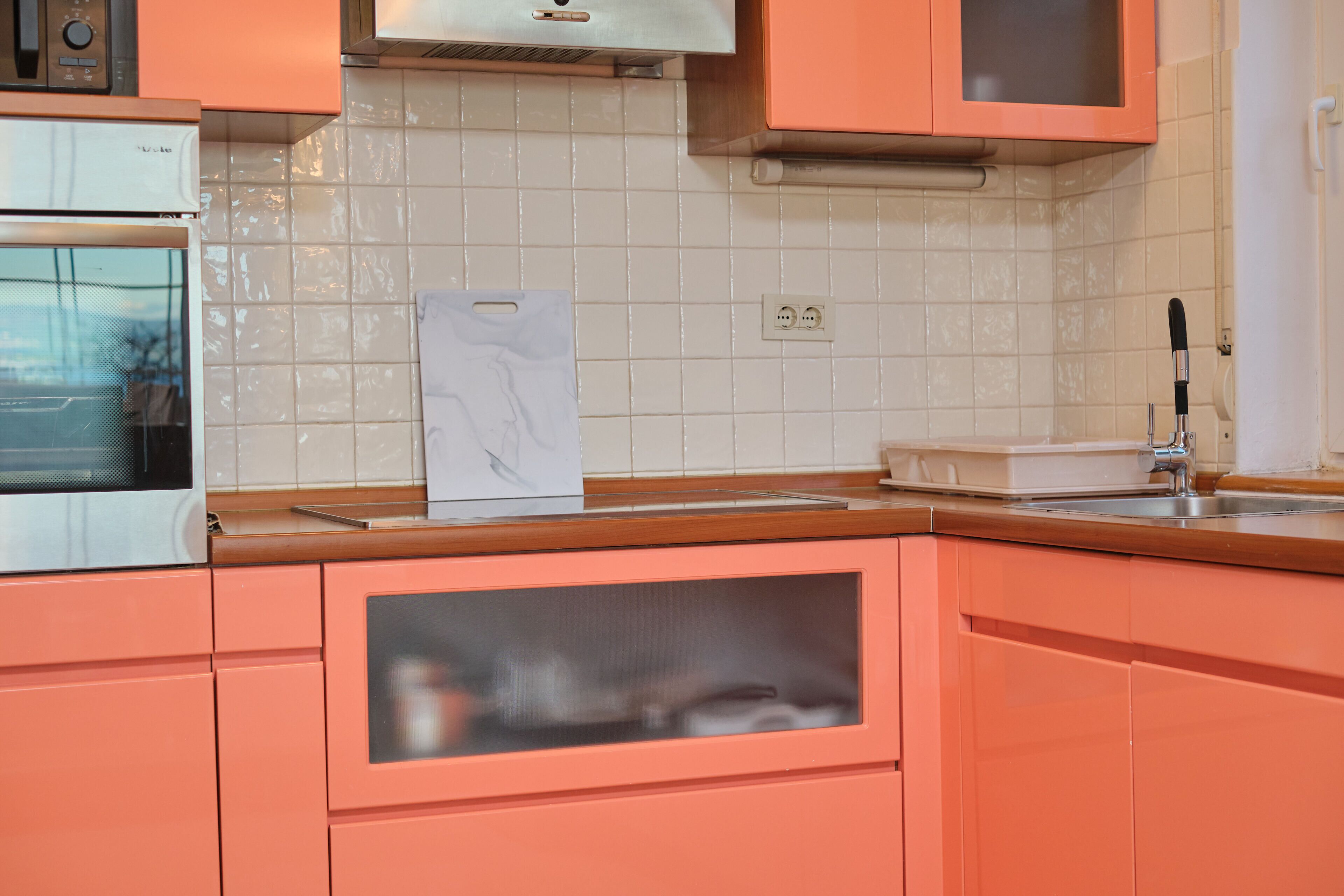 A kitchen with a microwave, oven, and a sink.