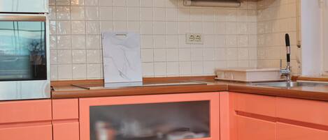 A kitchen with a microwave, oven, and a sink.