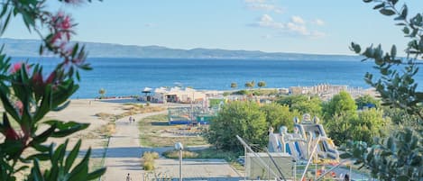 A coastal area with a playground, a walking path, and a view of the sea.