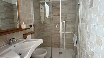 Un baño con ducha, lavabo e inodoro.