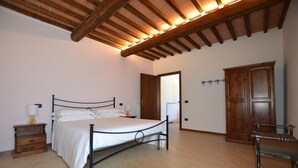 Une chambre à coucher avec un lit, une armoire en bois et une table de chevet avec une lampe.
