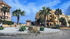Quartiere residenziale con palme, una rotonda e edifici dall'architettura mediterranea.