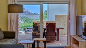 A room with a sofa, a TV, and a dining area with chairs and a table. - Anovi Holiday House by Litto (Okrug)