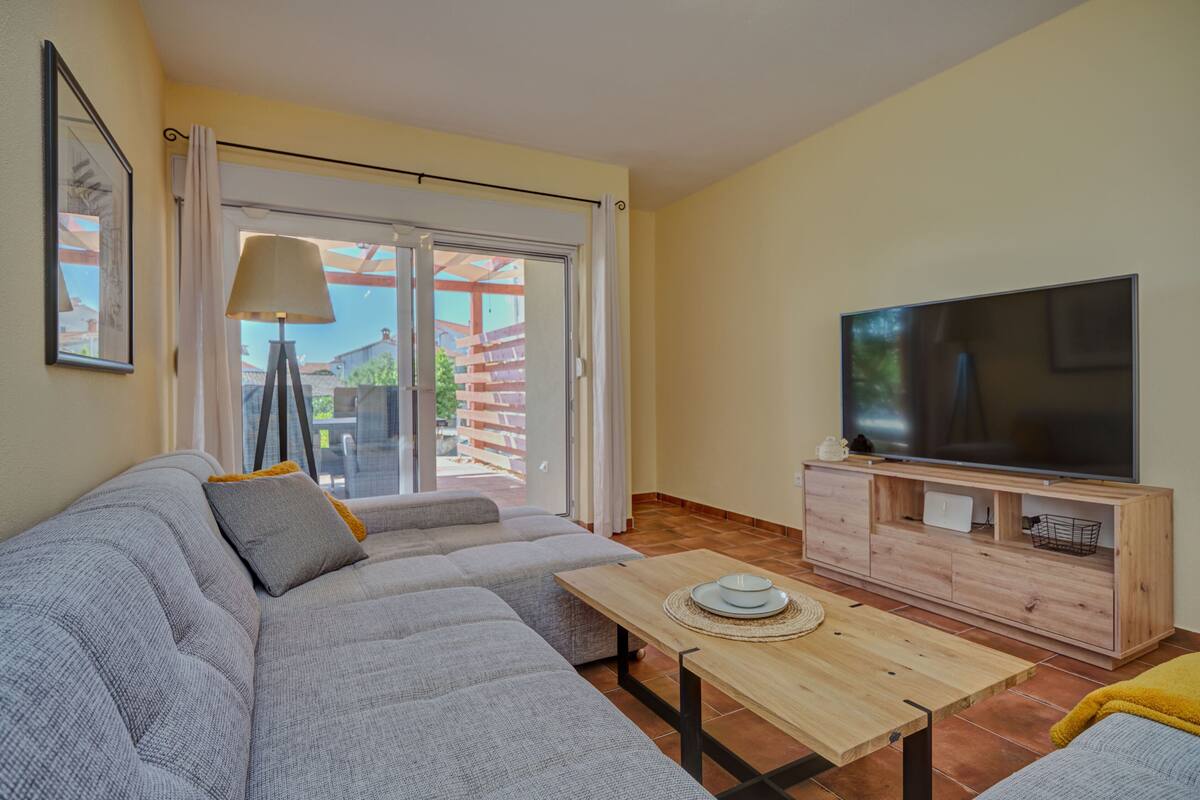 Ein Wohnzimmer mit einer Couch, einem Fernseher und einem Tisch.