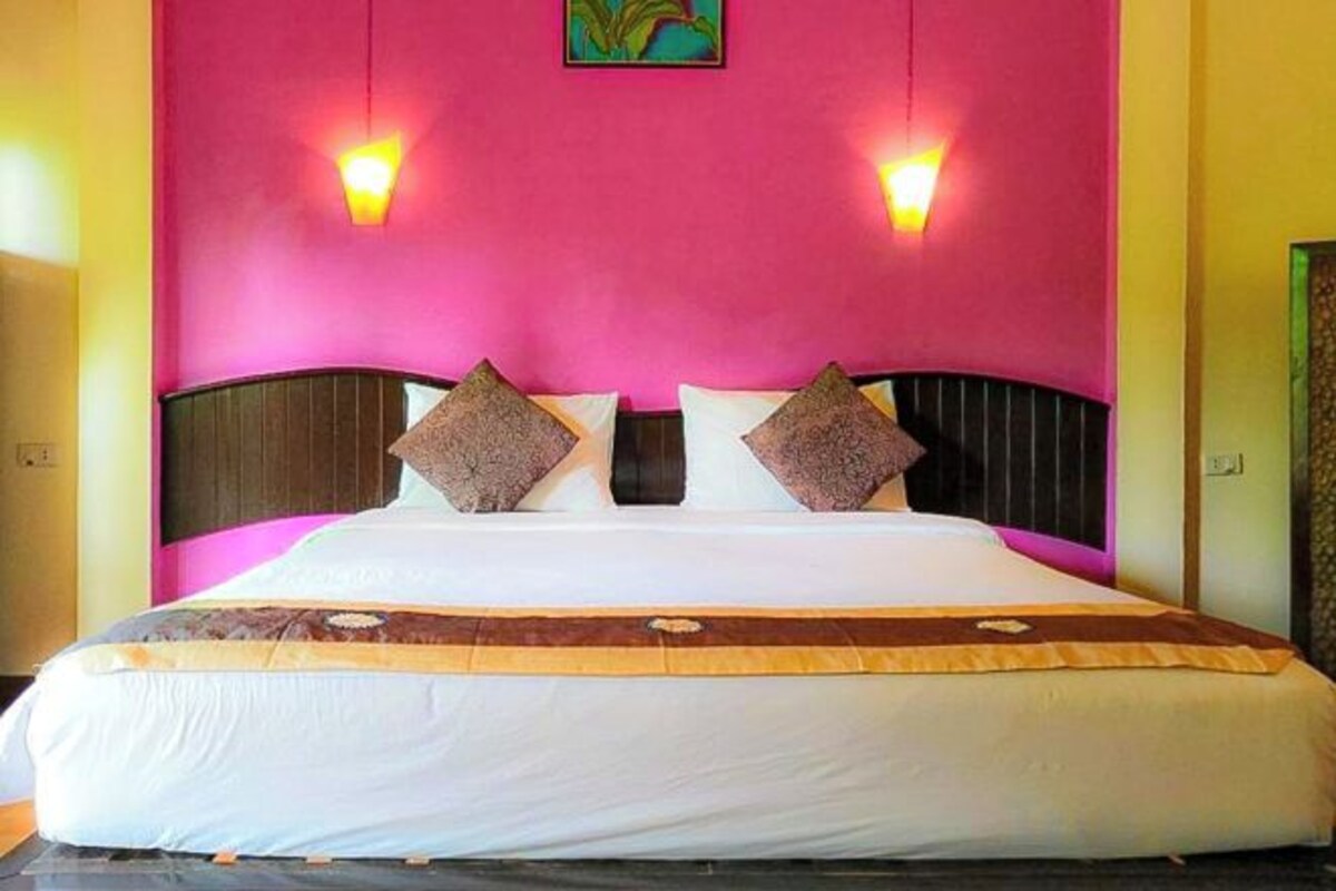 A bed with a headboard, pillows, and a blanket.