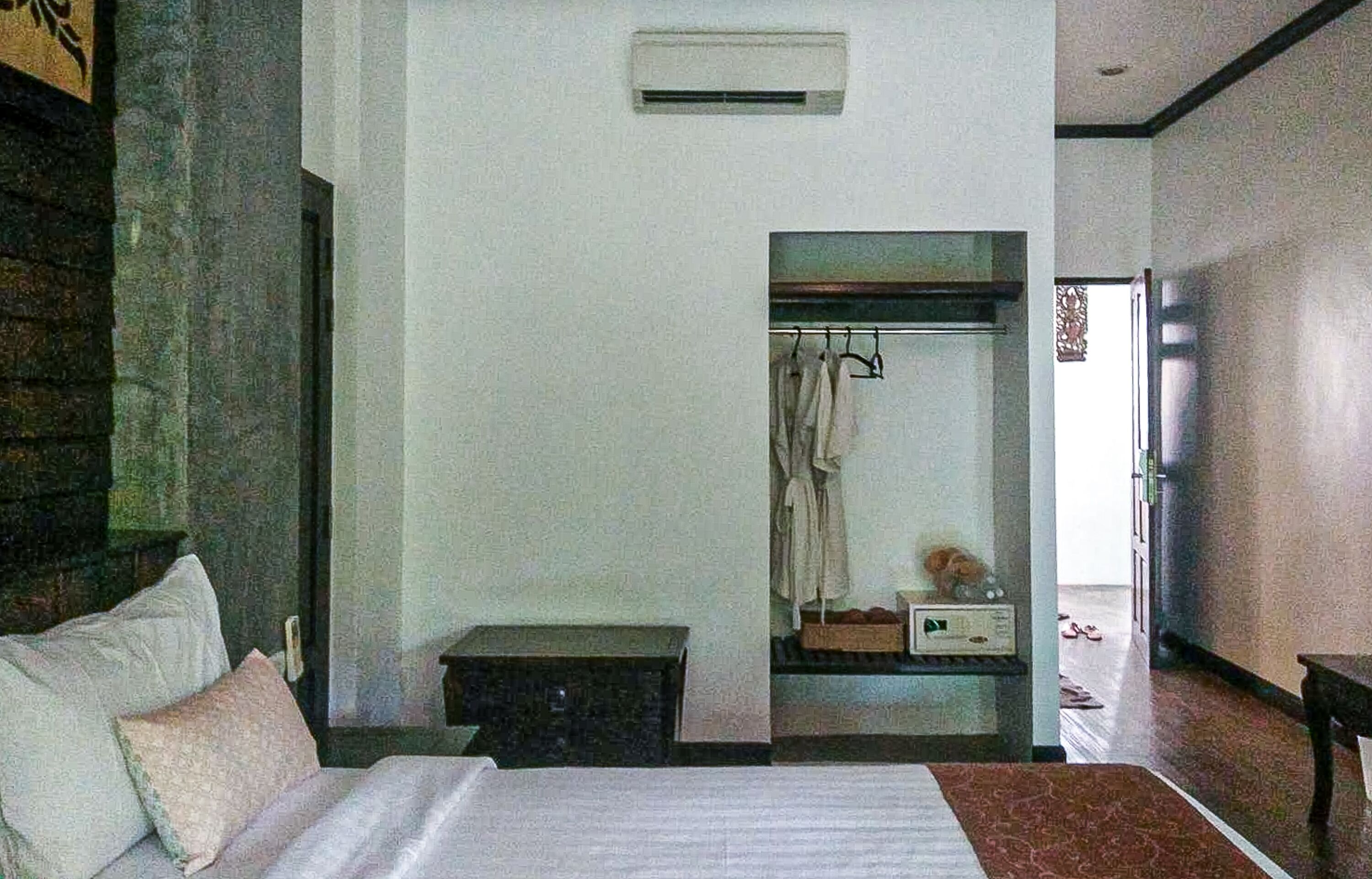 Un dormitorio con cama, mesita de noche y aire acondicionado.