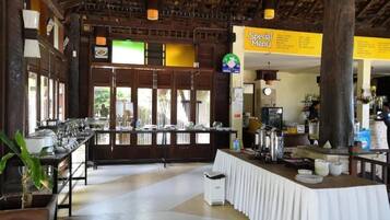 Un comedor amplio con una barra larga, un sistema de buffet y un cartel que dice 'Menú Especial'.