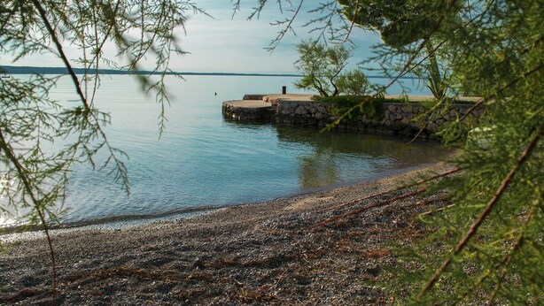 A calm lake with a stone pier extending into the water, surrounded by trees. - Comfortable accommodation for 4 people in the center of Starigrad (Starigrad)