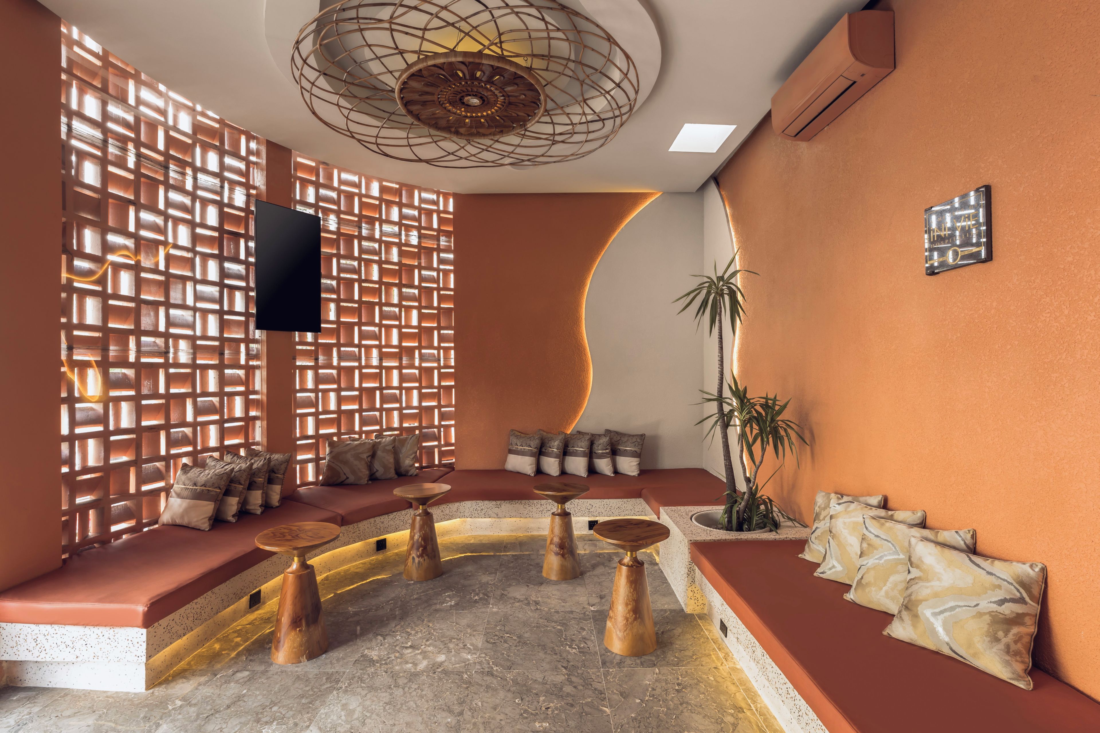 A modern interior with a seating area, a TV, and a decorative wall.