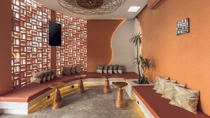 Un interno moderno con una zona salotto, una TV e una parete decorativa.